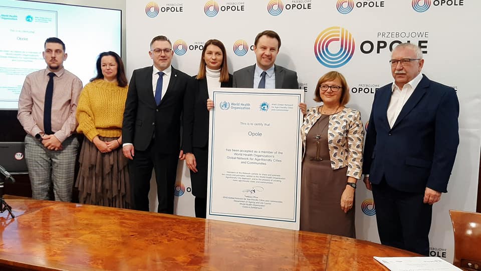 prezydent ze współpracownikami prezentuje certyfikat WHO