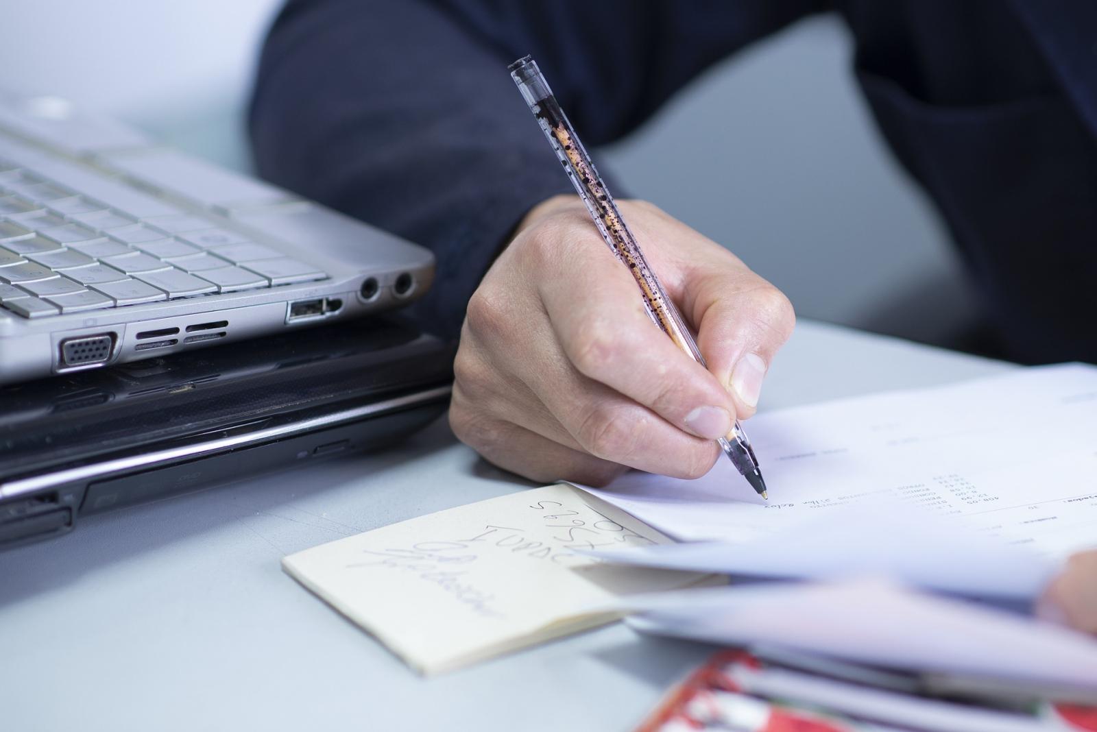 Osoba pisząca na kartce