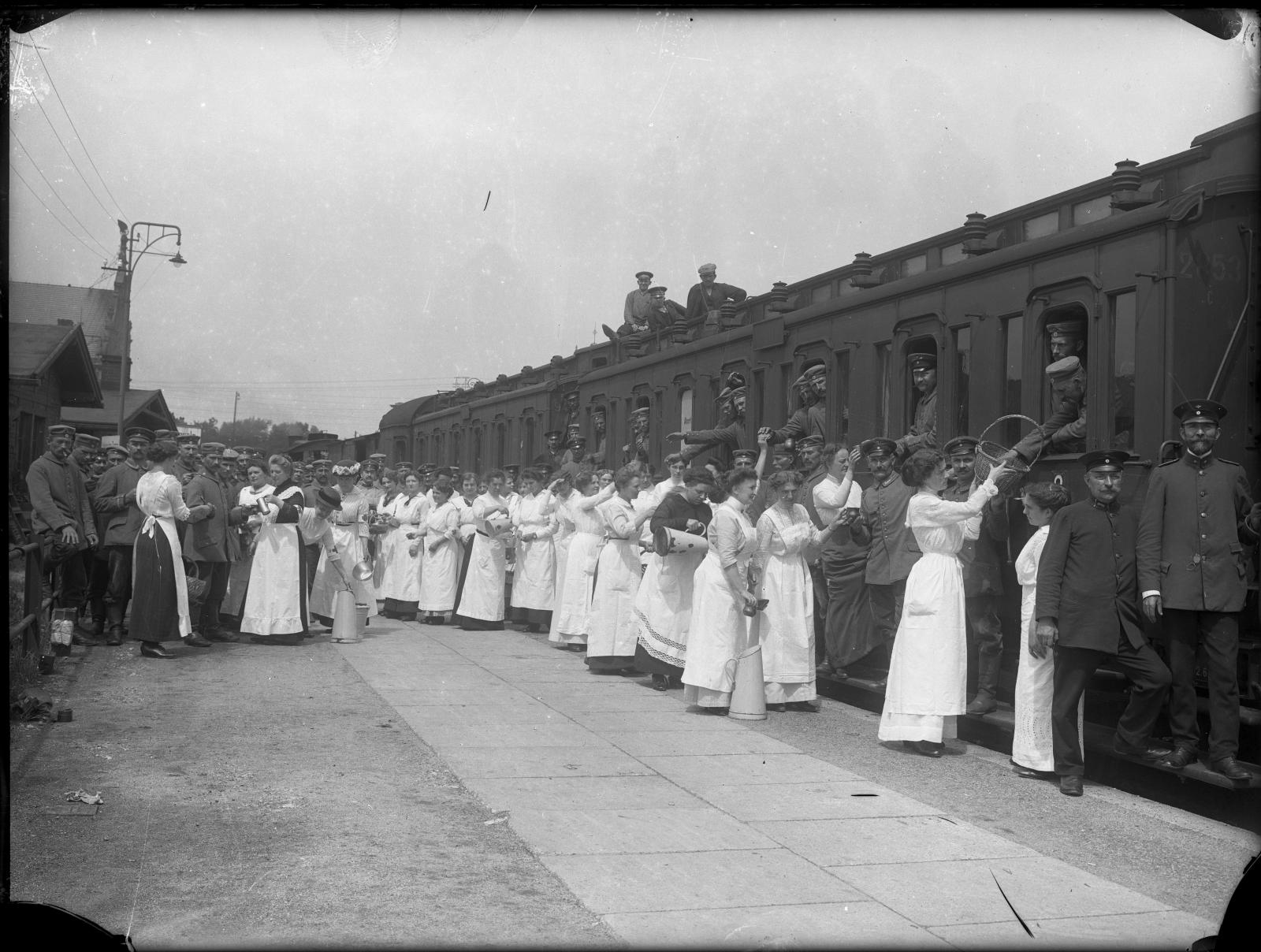 Peron dworca w czasie I wojny światowej. Kobiety z Czerwonego Krzyża rozdają żywność, około 1915 roku.