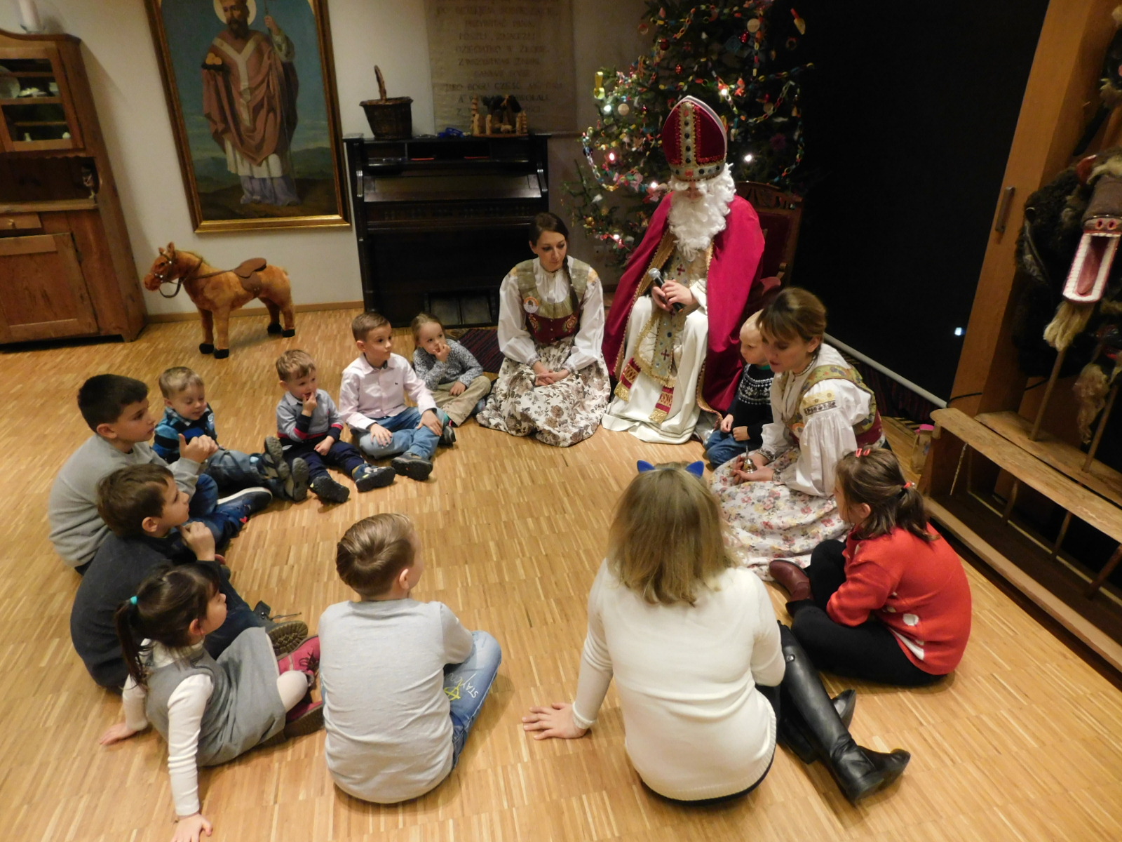 Dzieci siedzące w kółku ze świętym Mikołajem. Zdjęcie z archiwum Muzeum Wsi Opolskiej