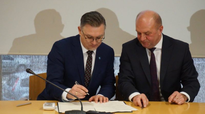Przemysław Zych podczas podpisywania porozumienia.