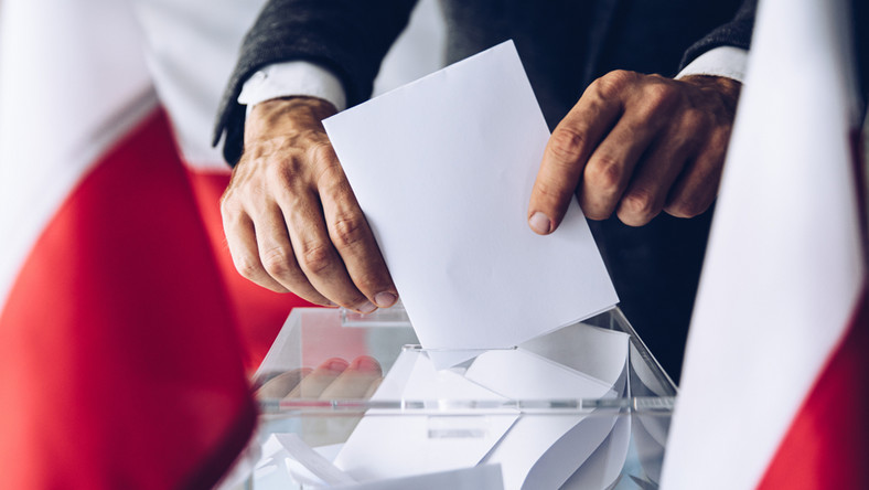 Wyborca wkładający kartę do urny