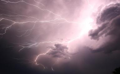 Zdjęcie przedstawia niebo z widocznymi błyskawicami oraz chmurami 