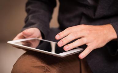 Osoba trzymająca tablet w dłoni 