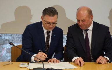 Przemysław Zych podczas podpisywania porozumienia.