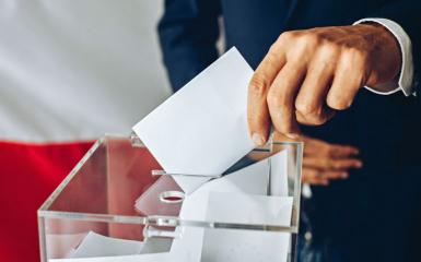 Wyborca wrzucający głos do urny