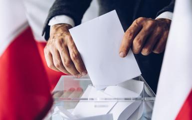 Wyborca wkładający kartę do urny