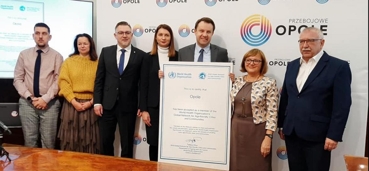 prezydent ze współpracownikami prezentuje certyfikat WHO