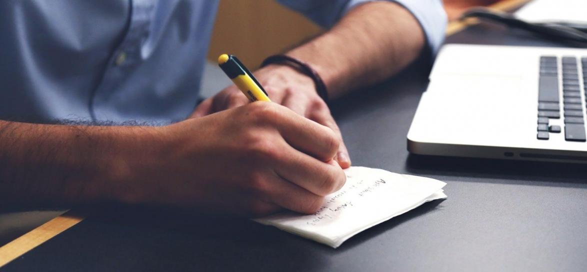 Osoba pisząca na kartce