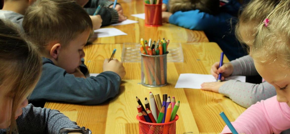 dzieci rysują przy biurku