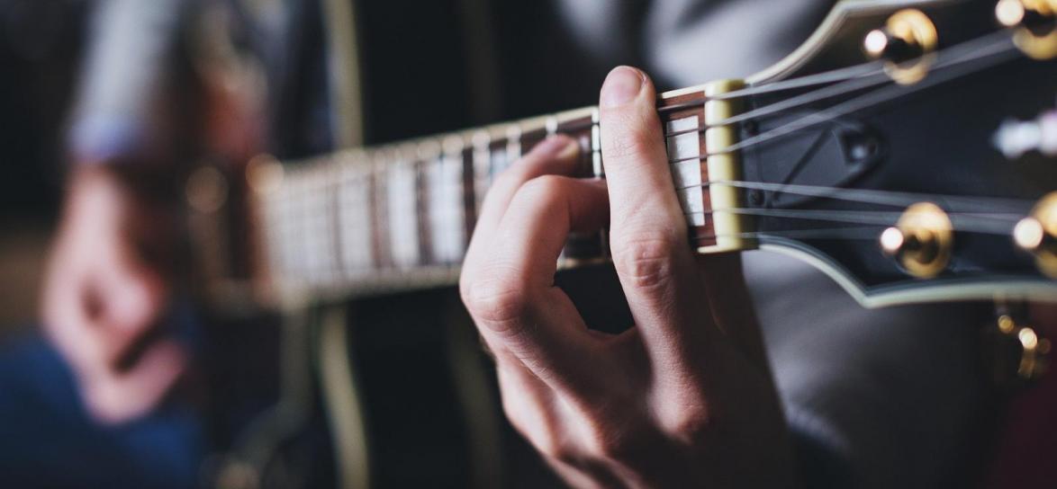 osoba grająca na gitarze