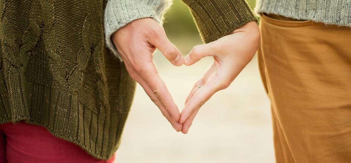 Dwie osoby z dłońmi splecionymi w serce