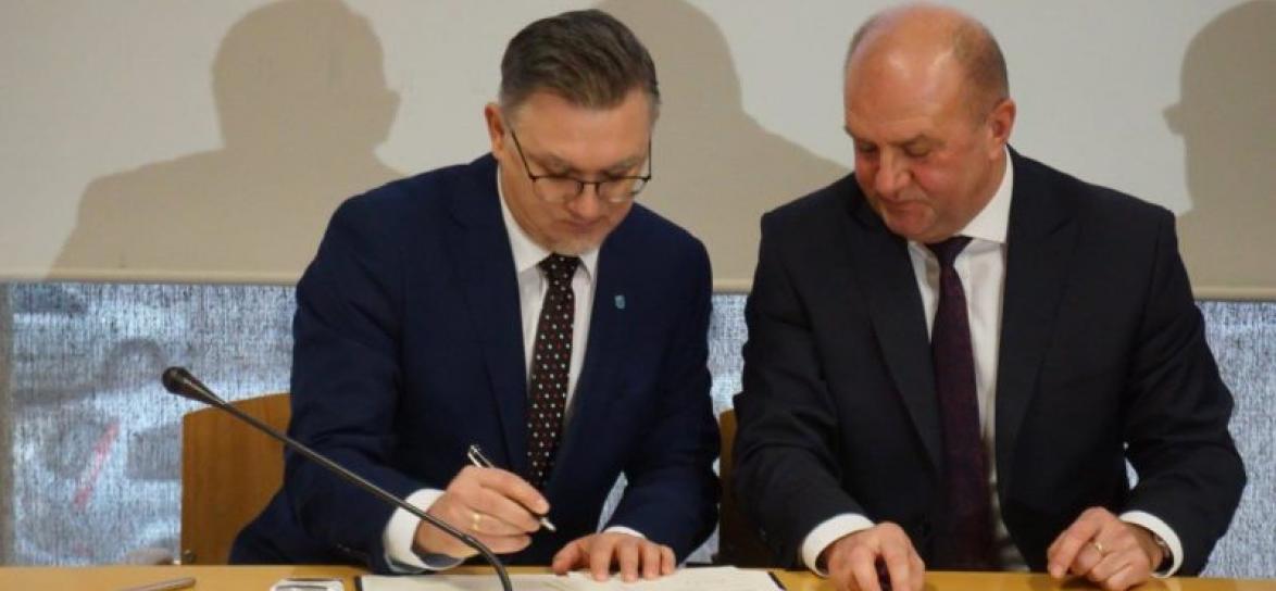 Przemysław Zych podczas podpisywania porozumienia.