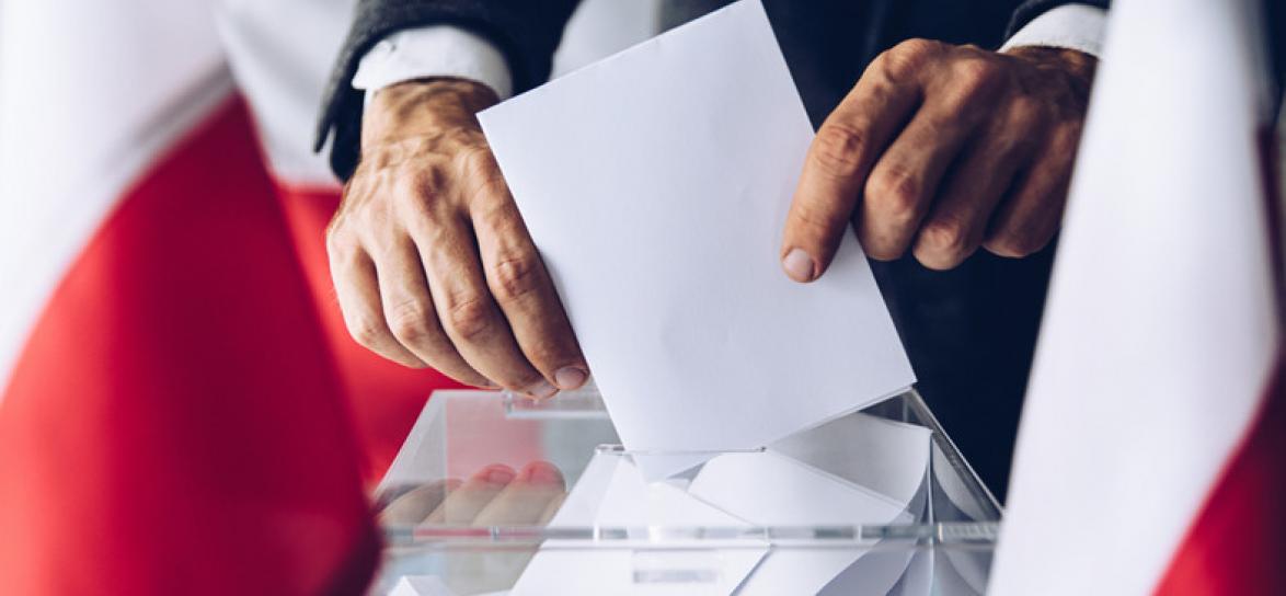 Wyborca wkładający kartę do urny